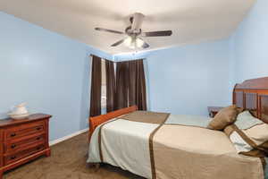 Bedroom featuring dark colored carpet and ceiling fan