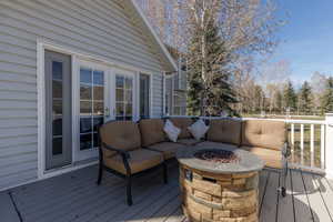 Deck featuring an outdoor living space with a fire pit and french doors