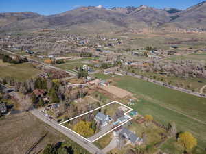 Overview of rural landscape with property parcel outlined, a mountain backdrop, and nearby suburban area