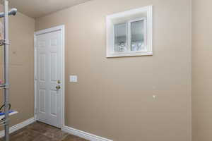 Doorway to outside featuring baseboards
