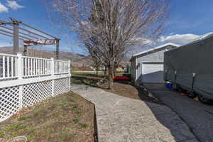 View of yard featuring a deck with mountain view, a garage, and an outbuilding