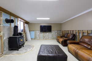 Living area featuring unfinished concrete flooring and a wood stove