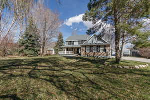 View of front facade featuring covered porch, a storage unit, and a front yard