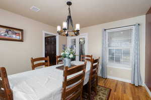 Dining space featuring wood finished floors and suspended lighting