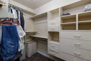 Walk in closet featuring dark colored carpet