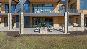 Rear view of house with a patio area and stone siding