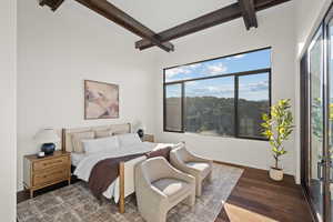 Bedroom featuring beamed ceiling and wood finished floors
