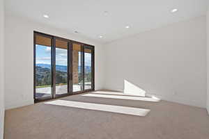 Carpeted empty room with a mountain view and recessed lighting