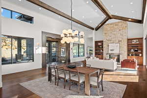Dining room featuring dark wood-type flooring, a fireplace, built in features, and vaulted ceiling