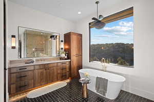 Bathroom featuring vanity, a soaking tub, and a shower stall