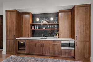 Bar area featuring open shelves, wood finish cabinets, beverage cooler, dark wood-style floors, and oven