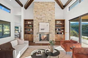 Living area featuring healthy amount of natural light, a stone fireplace, and wood finished floors