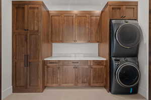 Laundry room with stacked washer / dryer and cabinet space