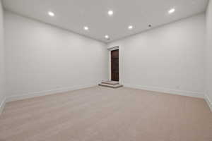 Unfurnished room with recessed lighting and light carpet