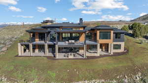 Rear view of property featuring a patio, a mountain view, and a yard