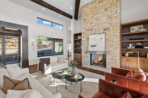 Living room featuring a stone fireplace, built in features, wood finished floors, and recessed lighting