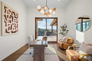 Office with wood finished floors, a chandelier, and healthy amount of natural light