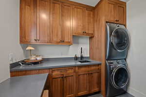 Laundry room with stacked washer / drying machine and cabinet space