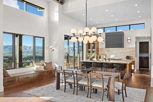 Dining space featuring dark wood-style floors, a mountain view, recessed lighting, plenty of natural light, and a high ceiling