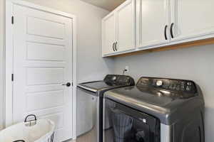 Laundry area featuring cabinet space and washing machine and clothes dryer
