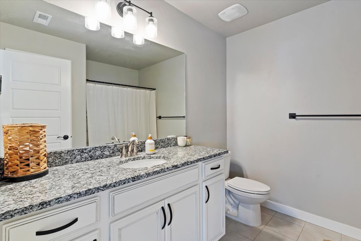 Bathroom with vanity, a shower with shower curtain, and light tile patterned flooring