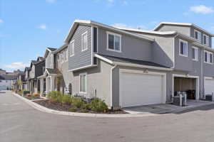 View of property exterior with stucco siding, a residential view, and a garage