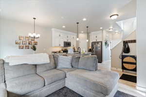 Living area featuring light wood-type flooring and a chandelier