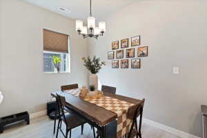 Dining area featuring light wood finished floors and suspended lighting