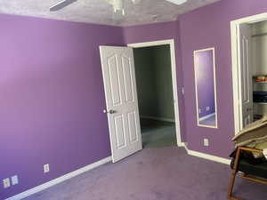 Bedroom featuring light carpet, a ceiling fan, fun purple color for daughters or playroom