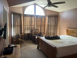 Bedroom featuring vaulted ceiling, light colored carpet, and ceiling fan