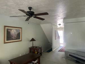 Living room featuring carpet floors, and ceiling fan