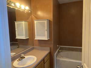 Bathroom featuring a bath and vanity
