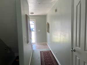Hall with light carpet, and light tile patterned floors