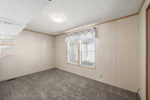 Bedroom with built-in shelving, large window, and comfortable layout.