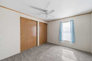 Bedroom with dual closets, ceiling fan, and natural light from window.