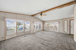 Alternate view of living space with front entry access and open sightlines to kitchen area.