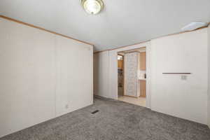 Secondary living or flex space with neutral tones and easy access to kitchen and main living areas.