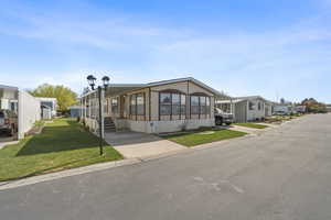 Angled exterior view showcasing covered entry, wide lot placement, and easy access to parking.