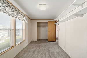Bedroom featuring open closet space, built-in shelving, and natural light.
