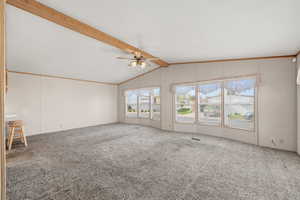 Bright and open living room with vaulted ceilings, large windows, and abundant natural light.