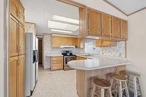 Kitchen with ample cabinet storage, breakfast bar seating, and included appliances.