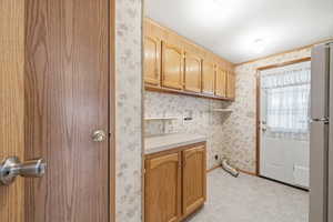 Laundry/utility room with built-in cabinets, extra storage space, and exterior access.