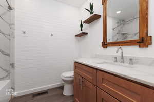 Full bath with vanity and dark wood finished floors