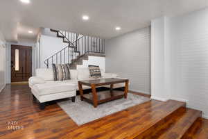 Living area featuring hardwood / wood-style floors, recessed lighting, and brick wall