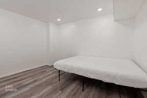 Bedroom with dark wood-style floors and recessed lighting