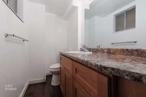 Half bathroom featuring vanity and dark wood finished floors
