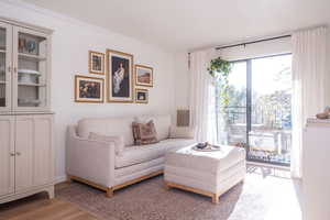Living area with light wood-style floors and ornamental molding