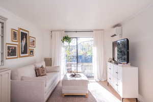 Living room featuring ornamental molding and light wood-type flooring