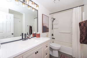 Bathroom featuring vanity and shower / bath combination with curtain