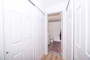 Bathroom with a shower with curtain, light wood-type flooring, and ornamental molding